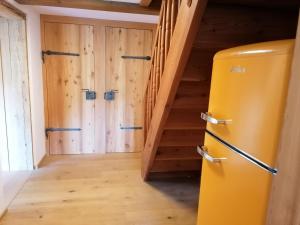 einen Kühlschrank in einem Zimmer mit Holzwänden und Treppen in der Unterkunft Ferienhaus Asterbach in Gosau