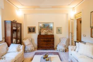 een woonkamer met 2 banken en een tafel bij La Romantica Veranda Free Parking and Garden in Lucca
