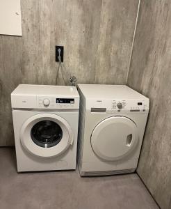 a washer and a washing machine in a room at Familievennlig Apartament in Tvedestrand