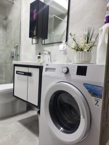 uma máquina de lavar roupa na casa de banho com um espelho em Tuana's Apartment em Shkodër