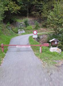 un pequeño camino con un cartel en el costado en Chalet Alpe Quaggiui, en Calasca Castiglione