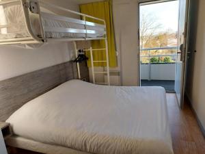 a bedroom with a bed and a balcony at Premiere Classe Saintes in Saintes