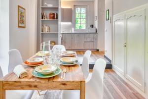 a dining room with a wooden table and white chairs at PORTOVECCHIO Plus in Levanto