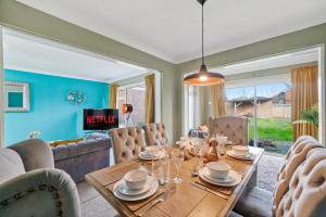 a dining room with a table and chairs at 4 Bed House with Parking and Garden - Sleeps 8 in Kent