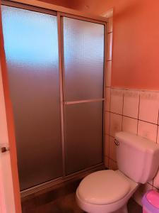 a bathroom with a toilet and a glass shower at Quinta El Espino in Ahuachapán