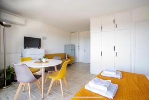 a living room with a table and yellow chairs at Cannes Marina suite vue mer in Mandelieu-La Napoule +7 photos