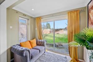 uma sala de estar com um sofá e uma grande janela em 4 Bed House with Parking and Garden - Sleeps 8 em Kent