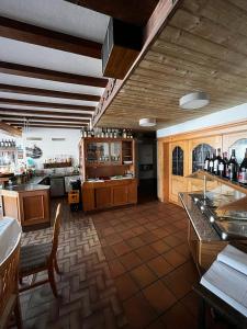 a large room with a bar and a kitchen with bottles of wine at Wohnungen bei Post in Hünfelden