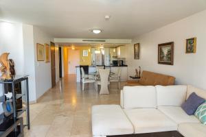 a living room with a white couch and a kitchen at A Star Oasis Condo in Palm-Eagle Beach