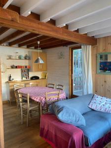 ein Wohnzimmer mit einem Tisch und einer Küche in der Unterkunft CHALET SAVINES LE LAC in Savines