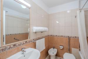 een badkamer met een wastafel, een toilet en een spiegel bij OBSIDIAN Apartamento Santa María in Adeje +13 foto's