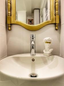 ein Waschbecken mit einem goldenen Spiegel darüber in der Unterkunft DELUX Le MARQUIS in Saverne