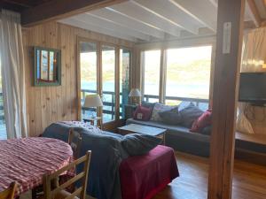 ein Wohnzimmer mit einem Sofa, einem Bett und Fenstern in der Unterkunft CHALET SAVINES LE LAC in Savines