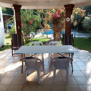 een witte tafel en stoelen op een patio bij Quinta El Espino in Ahuachapán