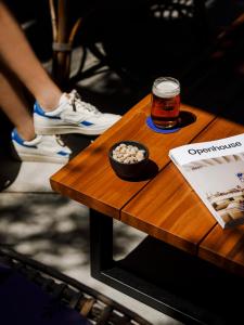 een houten tafel met een glas bier en een kom ballen bij Hotel Casa Nereta in Cadaqués