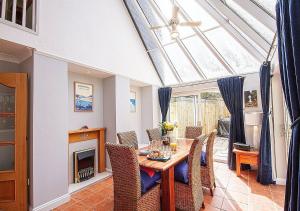 a dining room with a table and chairs and a fireplace at Orchard House Wadebridge Self Catering in Wadebridge