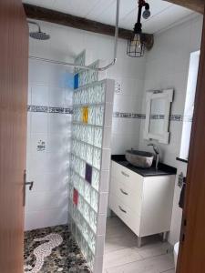a bathroom with a sink and a shower with glass panels at Lucky Lemons Boutique Houses Madeira 1 in Calheta +22 photos