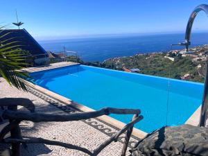a blue swimming pool with a view of the ocean at Lucky Lemons Boutique Houses Madeira 1 in Calheta