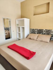 a red blanket laying on a bed in a room at Penginapan PIP Semarang in Jomblang