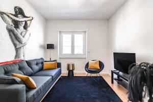 uma sala de estar com um sofá e uma televisão em Akicity Benfica Zenith em Lisboa