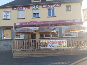 a hotel with umbrellas on the front of it at La Renaissance in Condé-sur-Noireau