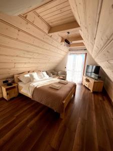 a bedroom with a large bed in a wooden room at Rozeta in Witów