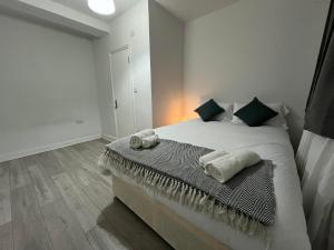 a bedroom with a bed with two towels on it at City Apartments near Seven Sisters in London