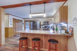 a kitchen with wooden cabinets and a counter with stools at Lovely Interlaken Home with Pool, Fire Pit and Yard! in Interlaken