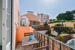 a balcony with a wooden bench on a building at Oeiras 2 in Oeiras