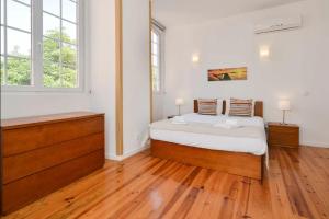 a bedroom with a bed and two windows at Oeiras 2 in Oeiras