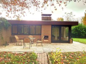 a house with a patio with a table and chairs at Vrijstaande vakantiebungalow met optimale privacy!! in Rekem