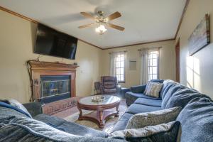 a living room with a blue couch and a fireplace at Lovely Fayetteville Home Deck and Fireplace! in Fayetteville