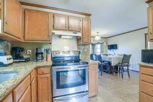 a kitchen with wooden cabinets and a stove top oven at Lovely Fayetteville Home Deck and Fireplace! in Fayetteville