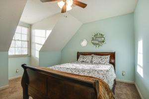 Lovely Fayetteville Home Deck and Fireplace! في فايتفيل: غرفة نوم بسرير ومروحة سقف
