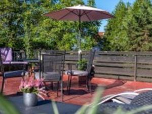 a patio with an umbrella and a table and chairs at Pension Haus Monika in Sasbachwalden