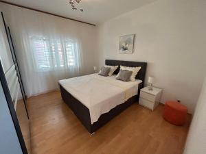 a bedroom with a large bed in a white room at Apartmani Pavlović in Sućuraj