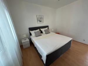 Un dormitorio blanco con una cama grande con dos almohadas. en Apartmani Pavlović, en Sućuraj 46 fotos más