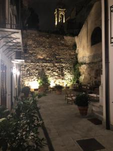 a building with a stone wall with benches and lights at Baglio San Giovanni in Palermo