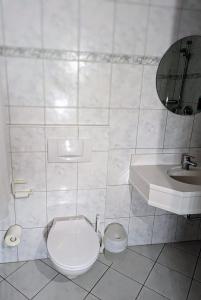 a white bathroom with a toilet and a sink at City Hotel - Einzelzimmer in Rastatt