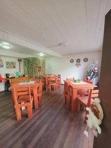 comedor con mesas de madera y sillas de madera en Hostal Paradise Blue en Osorno