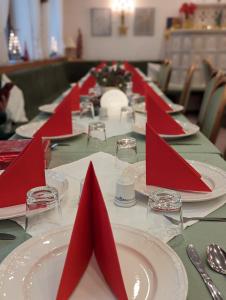 une longue table avec des serviettes rouges et des assiettes dessus dans l'établissement City Hotel - Einzelzimmer, à Rastatt
