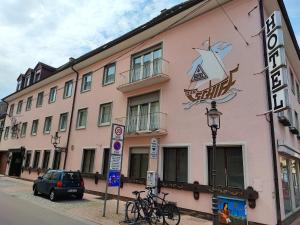 un bâtiment rose avec des vélos garés devant lui dans l'établissement City Hotel - Einzelzimmer, à Rastatt
