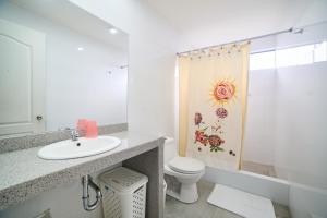 a bathroom with a sink and a toilet and a shower at Carolina Egg Gasthaus in Oxapampa