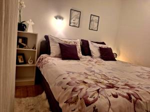 a bedroom with a bed with a floral comforter at Gospic Riverside Apartment in Gospić