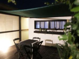 a patio with a table and chairs and windows at Studio Centro Garopaba in Garopaba