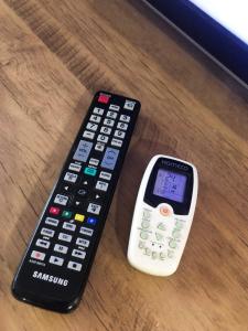 two remote controls sitting on top of a table at Studio Centro Garopaba in Garopaba