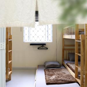 a room with two bunk beds and a window at Vit-troi Room - Family 5 person - Duck Homestay Ben Tre in Ấp Phú Lợi