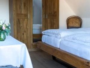 1 dormitorio con cama, mesa y espejo en Pension Haus Monika, en Sasbachwalden