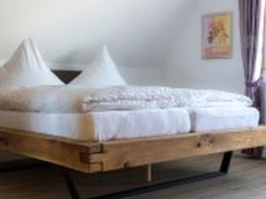 1 cama en una plataforma de madera en una habitación en Pension Haus Monika, en Sasbachwalden