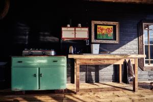 een keuken met een groene kachel en een houten tafel bij Blickinsfreie - Cabin in Schöneck